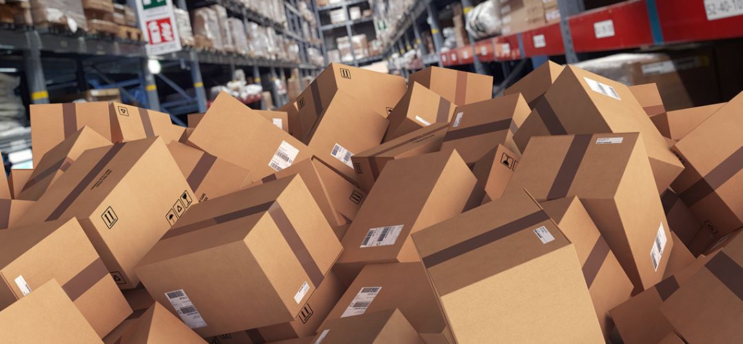 Cardboard boxes piled high in a warehouse due to over capacity